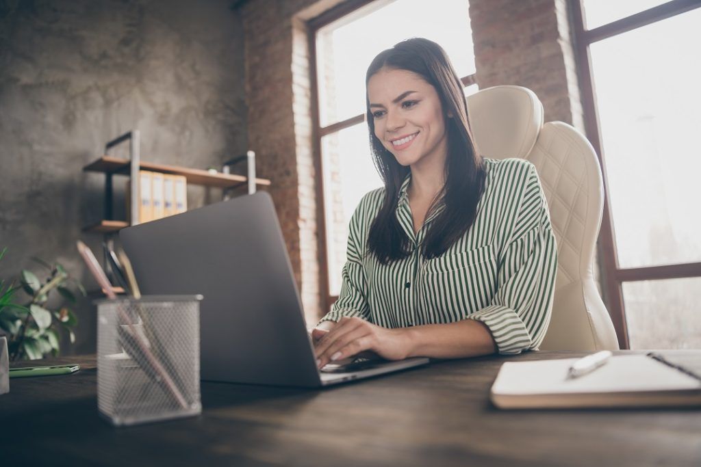 Business Writing - Image of a woman typing a letter on her laptop