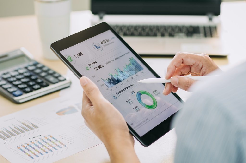 Businessman analyzing a company's sales report with dashboard at modern office space
